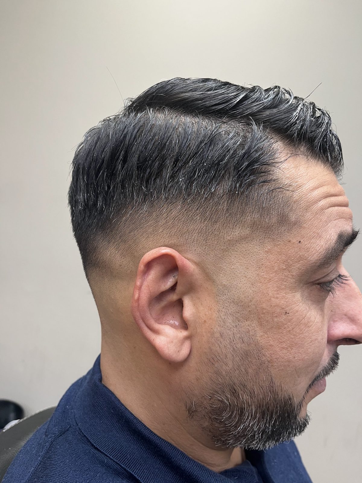 Klant van opzij met een taper, getextureerde bovenkant en verzorgde baard